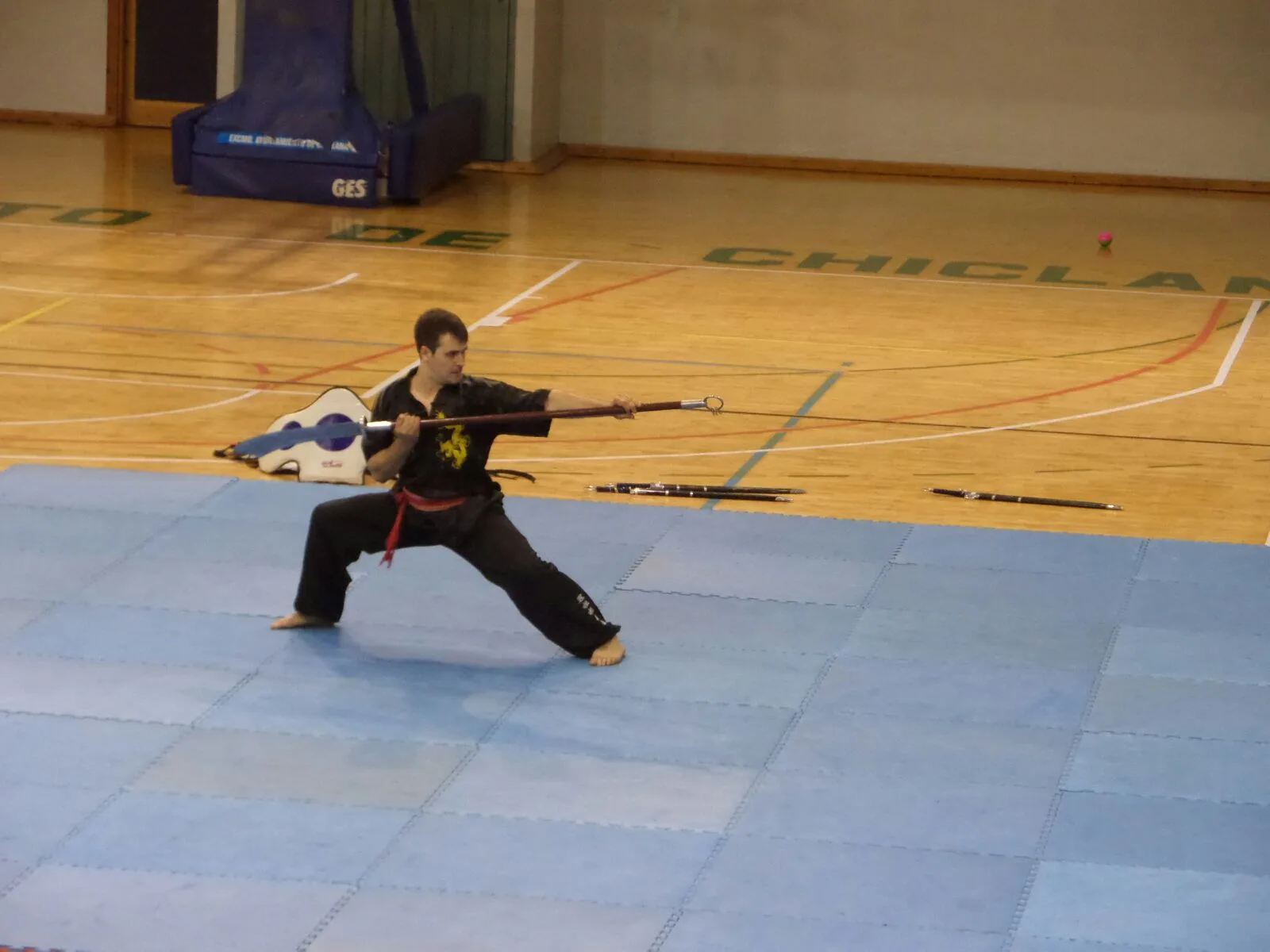 Alumno en postura de lanza durante una forma de wushu Alumno en postura de lanza durante una forma de wushu